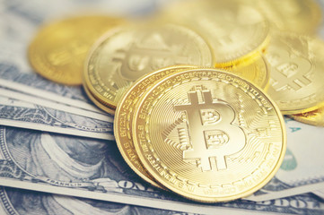 Golden bitcoin cryptocurrency on us dollars close up