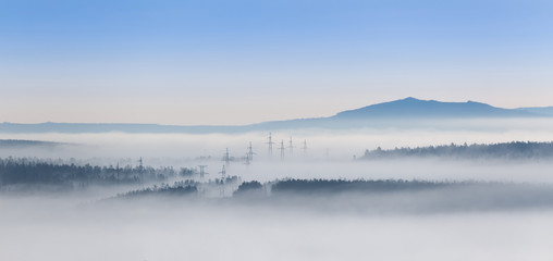 Landscape with an electricity pylon in the fog