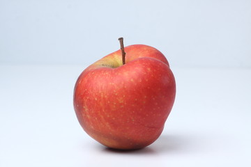 Concept of ugly food - red apple on white background