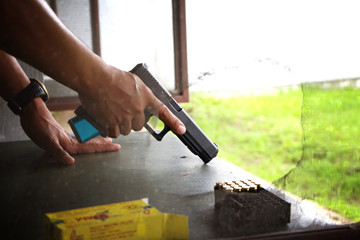 Blurry A man holding a gun in hand ready to shooting practice at targets paper.