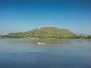 river view of Kaeng Kud Ku, beautiful peak mountain in Laos around with Mekong river and small boat with blue sky background, attraction in Chiang Khan, Loei, Thailand.