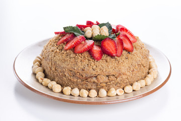Medovik – Russian layer honey cake with delicious sour cream frosting. Garnished with hazelnuts and strawberry slices 