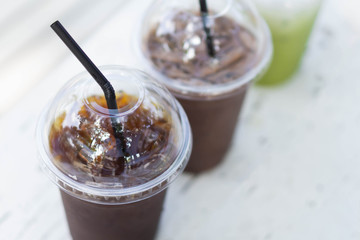 Close up glass of ice americano coffee on wood table, selective focus