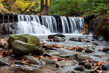 Colorful majestic waterfall in autumn forest