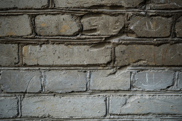 Texture of an old paint covered brick wall. Background image of an abandoned brick wall with painted over paint