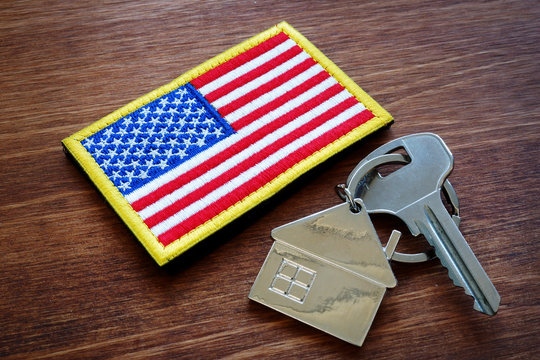 Key from property and USA flag. VA loan mortgage concept.