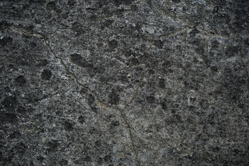 Texture of an old cracked concrete wall. Background image of a worn gray concrete surface