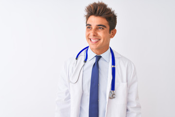 Young handsome doctor man wearing stethoscope over isolated white background looking away to side with smile on face, natural expression. Laughing confident.