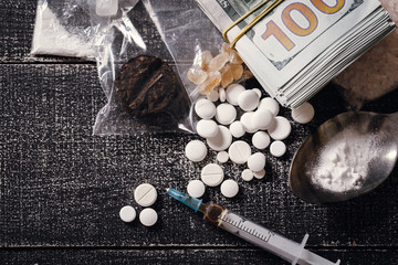 Fototapeta na wymiar Hard drugs on dark table.Addiction concept. Drug syringe and cooked heroin