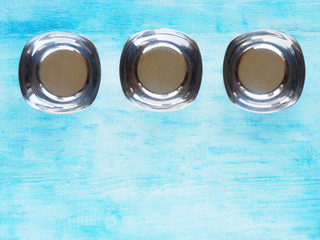 Three iron cup on a blue wooden background