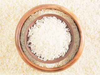 Rice in bowl and clay plate. Background from basmati rice. Indian cuisine ingredients
