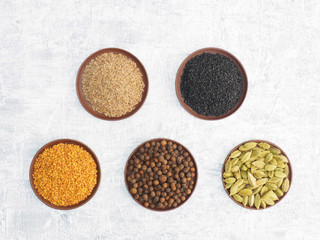 Spices and herbs set on concrete background in clay plate. Modern apothecary, naturopathy and ayurveda concept.