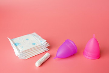 Menstrual cup, tampon on pink background. Alternative feminine hygiene product during the period. Women health concept. Copy space. Eco friendly concept, zero waste product. Flat lay, mockup, template