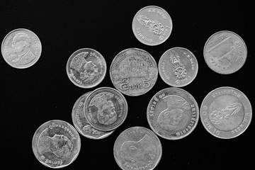 Thai Baht coins on a dark background close-up, black and white