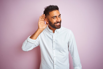 Young indian businessman wearing elegant shirt standing over isolated pink background smiling with...
