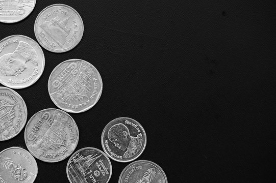 Thai Baht coins on a dark background close-up, black and white