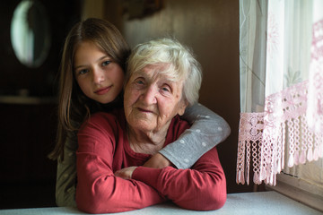 Portrait of little girl and her grandmother in his home.
