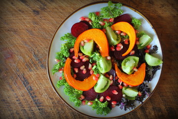 Healthy vegetarian salad, roasted pumpkin, tomato,pomegranate, kale, beet