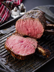 Grilled piece of meat with bone in a grill pan. Fried steak. Roasting - Medium Rare