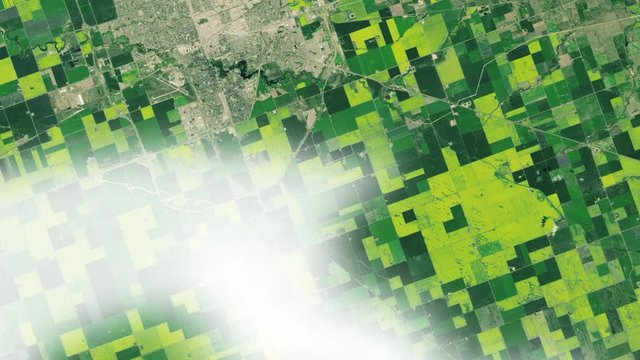 Large agricutural green field pattern canola plant oil production in Canada and Regina city aerial satellite view. Contains public domain image by Nasa