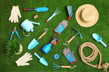 Set of gardening tools on green grass, flat lay