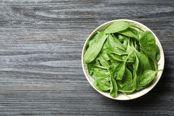 Fresh green healthy spinach on dark wooden table, top view. Space for text