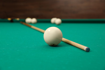 Billiard balls and cue on table indoors
