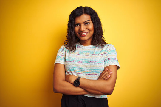 Beautiful transsexual transgender woman wearing t-shirt over isolated yellow background happy face smiling with crossed arms looking at the camera. Positive person.