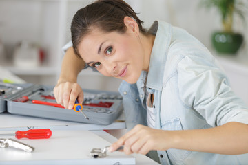 portrait of woman assembling a kitchen cupboard