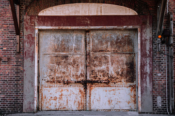 White old rusty iron gate with red brick wall loft warehouse