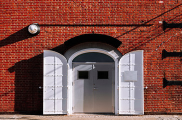 White iron gate with red brick wall old loft warehouse