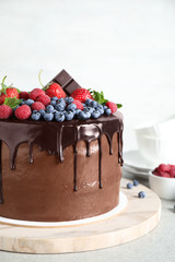 Freshly made delicious chocolate cake decorated with berries on white table