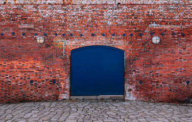 Blue iron gate with red brick wall old loft warehouse