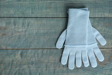 Stylish gloves on blue wooden background, top view with space for text. Autumn clothes