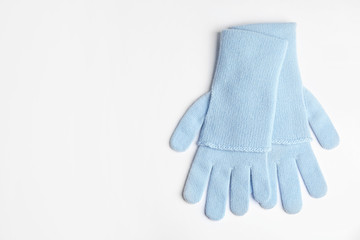 Stylish blue gloves on white background, top view with space for text. Autumn clothes