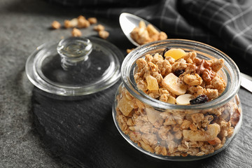 Jar of tasty homemade granola on grey table. Healthy breakfast