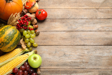Flat lay composition with autumn vegetables and fruits on wooden background, space for text. Happy Thanksgiving day