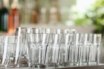 Empty glasses on wooden table against blurred background