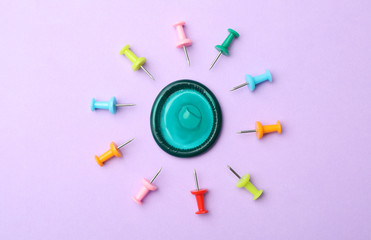 Flat lay composition with condom and pins on violet background