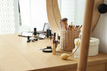 Cosmetics and brushes on dressing table in makeup room