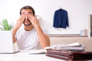 Young male student preparing for exams at home