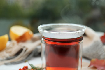 Cup of hot drink on window sill, closeup. Cozy autumn atmosphere