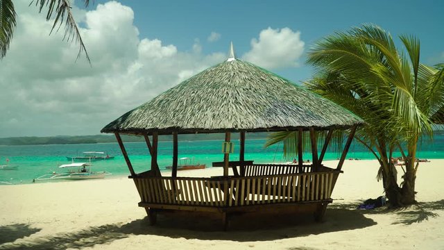 Tropical beach with bungalow under palm trees of Daco, Philippines. Summer and travel vacation concept