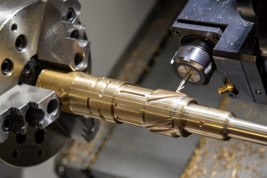 The CNC lathe,multi-tasking machine cutting the groove  slot at the brass shaft with the milling spindle by solid endmill tools. Metal working process by CNC turning machine for automotive industrial.