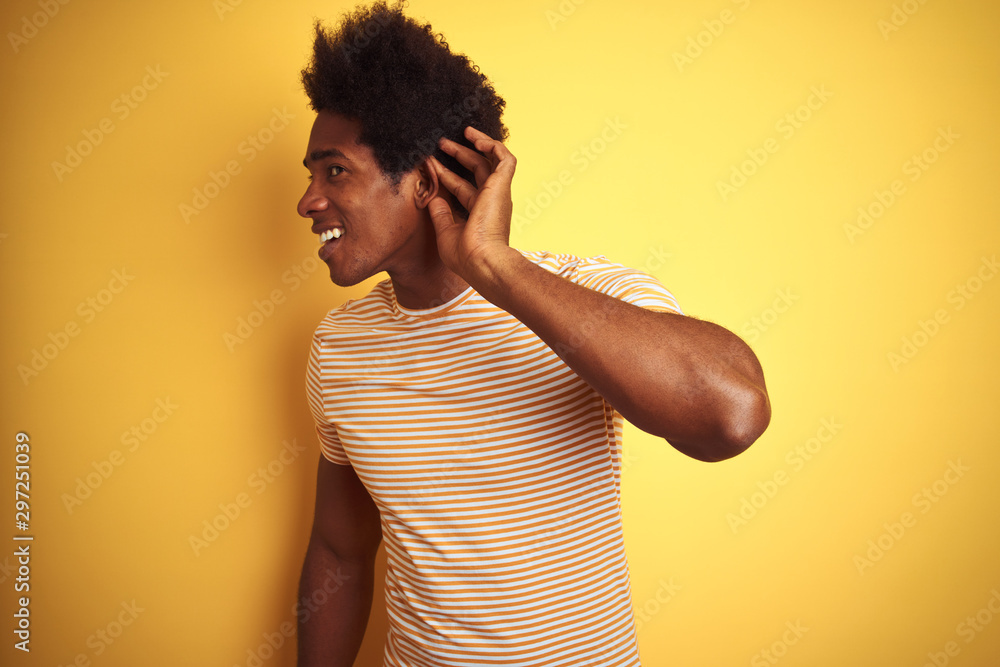 Sticker american man with afro hair wearing striped t-shirt standing over isolated yellow background smiling