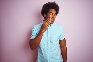 Fototapeta na wymiar Young american man with afro hair wearing blue shirt standing over isolated pink background touching mouth with hand with painful expression because of toothache or dental illness on teeth