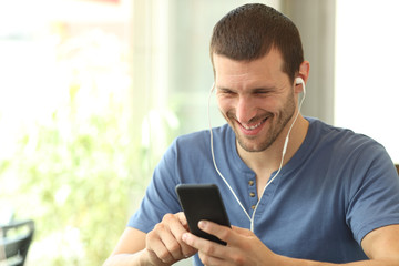Obraz na płótnie Canvas Happy man listening to music in a coffee shop