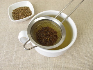 Tea from caraway seeds and caraway fruits in the tea strainer 