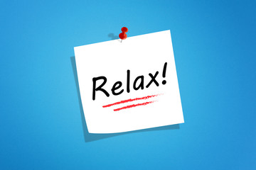 White post it note paper with relax message on blue background