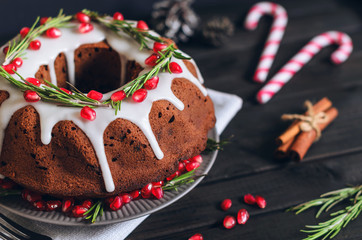 Homemade chocolate Christmas cake decorated with rosemary and pomegranate, front view